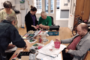 Patients and staff making a handmade bird feeder.