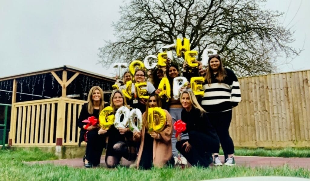 The team at Buttons with balloons saying 'together we are good'.