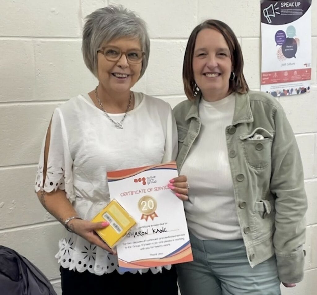 Sharon posing with her 20 year certificate.