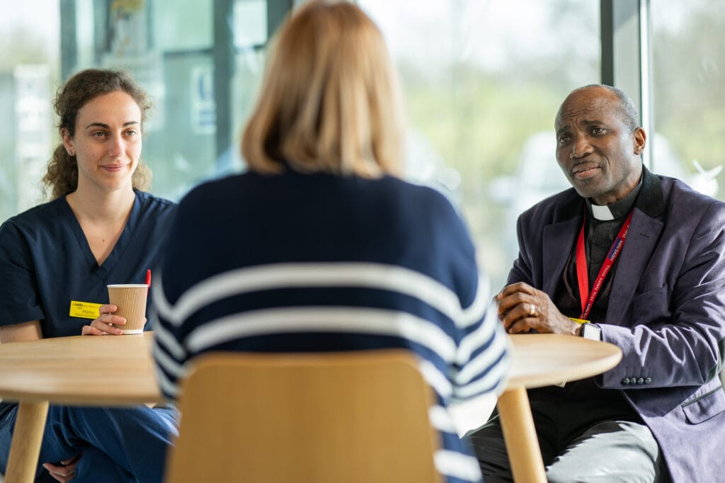 Ola and two other people sat round a table.